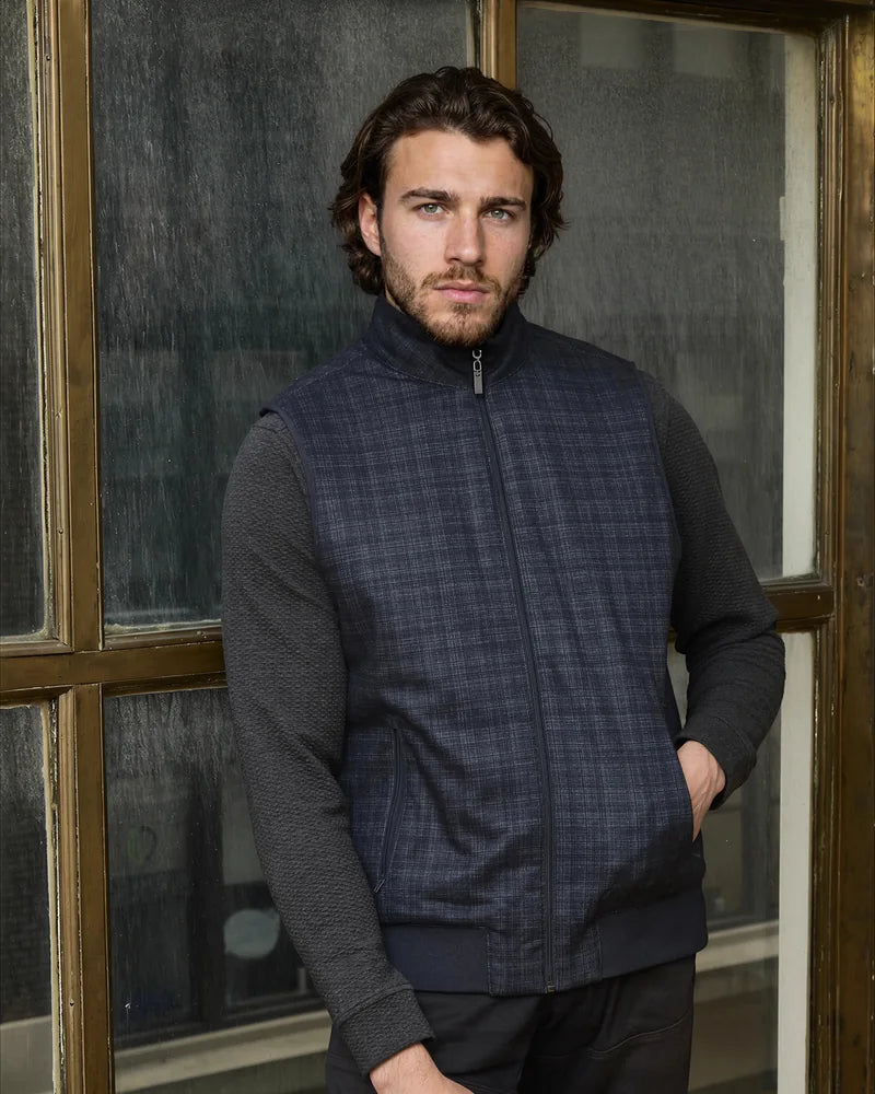 Model wearing a navy Reversible Plaid Puffer Vest