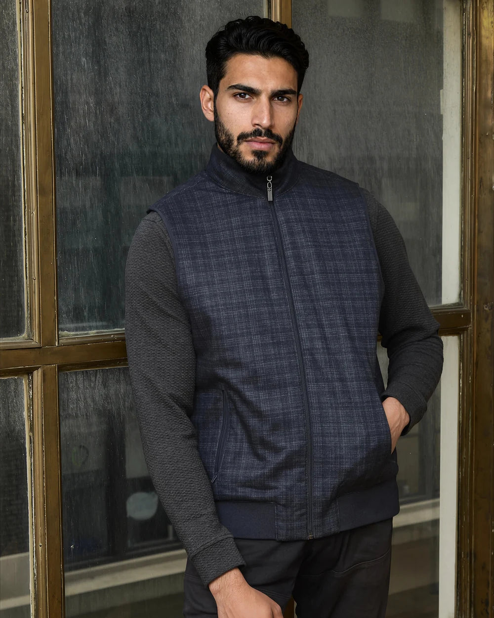 Model standing in the navy Reversible Plaid Puffer Vest